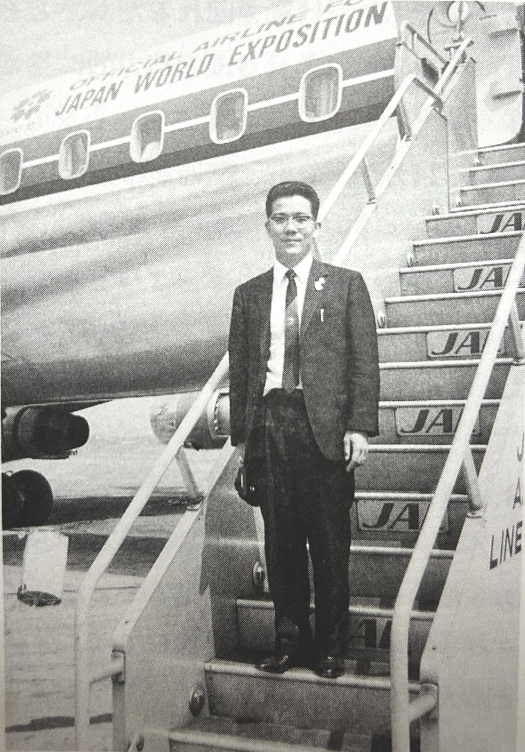 飛行機のタラップに載る和気博史さん